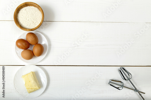 flour, eggs and butter on a white table - dough ingredients