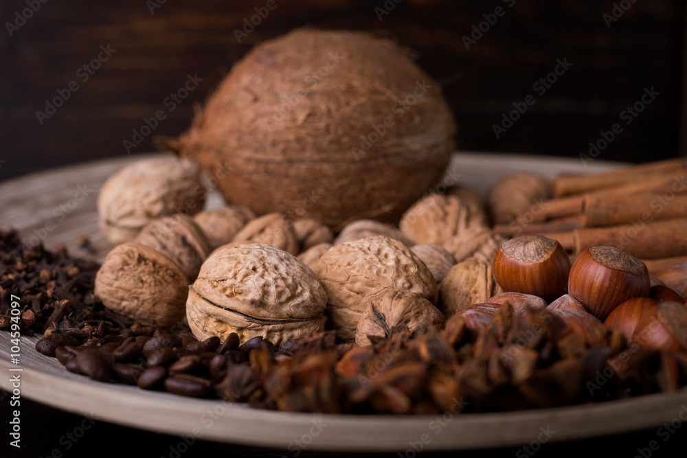 spices for baking, cinnamon sticks, star anise, cloves, nuts, coconut, coffee beans on a wooden background spices for baking, cinnamon sticks, star anise, cloves, nuts, coconut, coffee beans on a wooden background