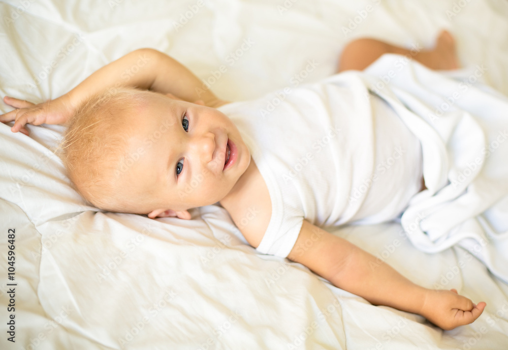 baby lying on the bed and smiling baby lying on the bed and smiling