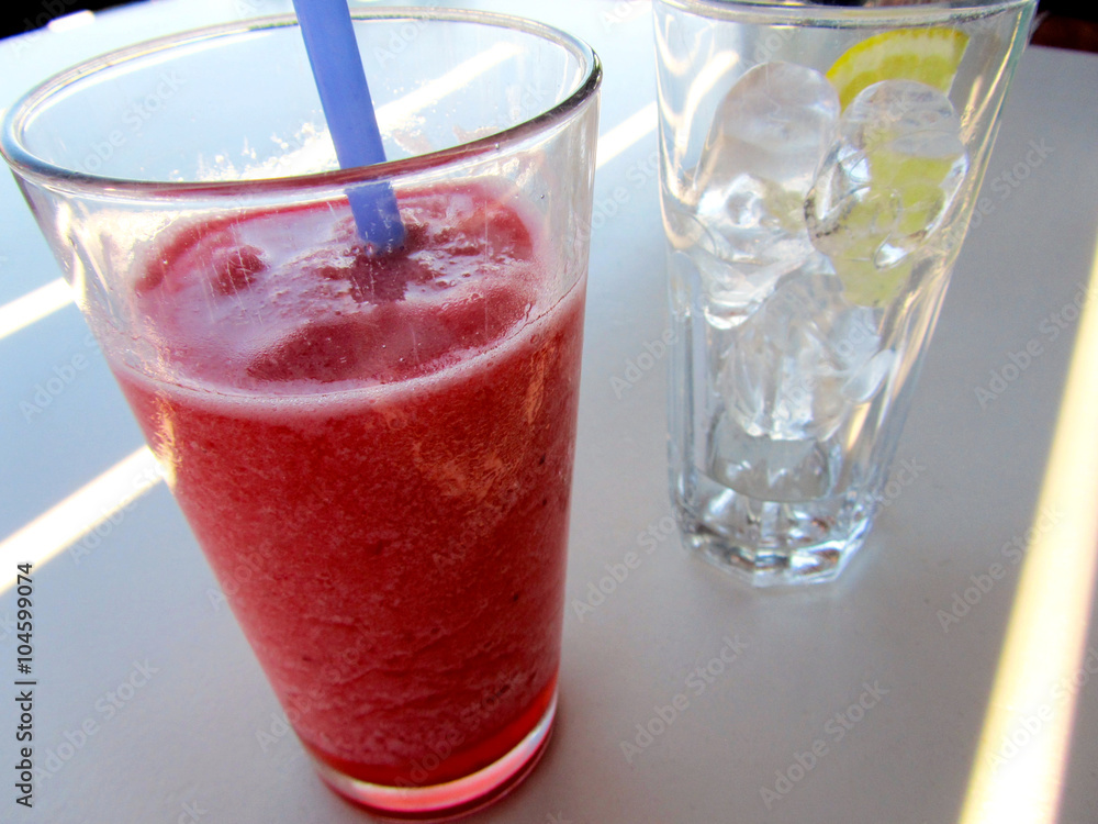 Granita alla fragola e bicchiere pieno di ghiaccio con limone Granita alla fragola e bicchiere pieno di ghiaccio con limone