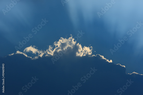 Deep sky background. Unusual cloud with a luminous edge and rays of the sun.