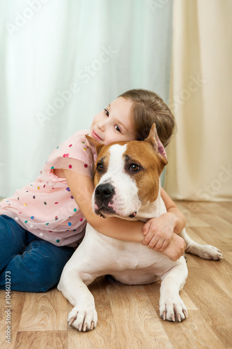 Little girl with staffordshire terrier dog