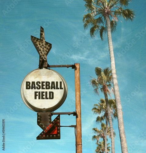 aged and worn vintage photo of baseball field sign with palm trees