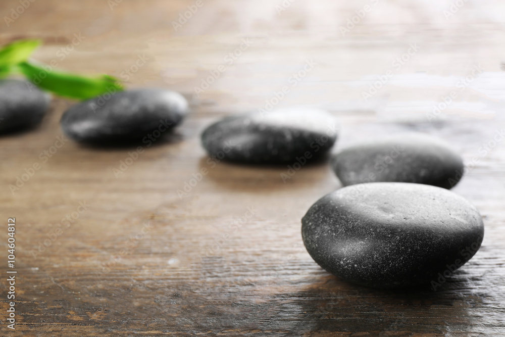 Spa stones and bamboo branch on wooden background Spa stones and bamboo branch on wooden background