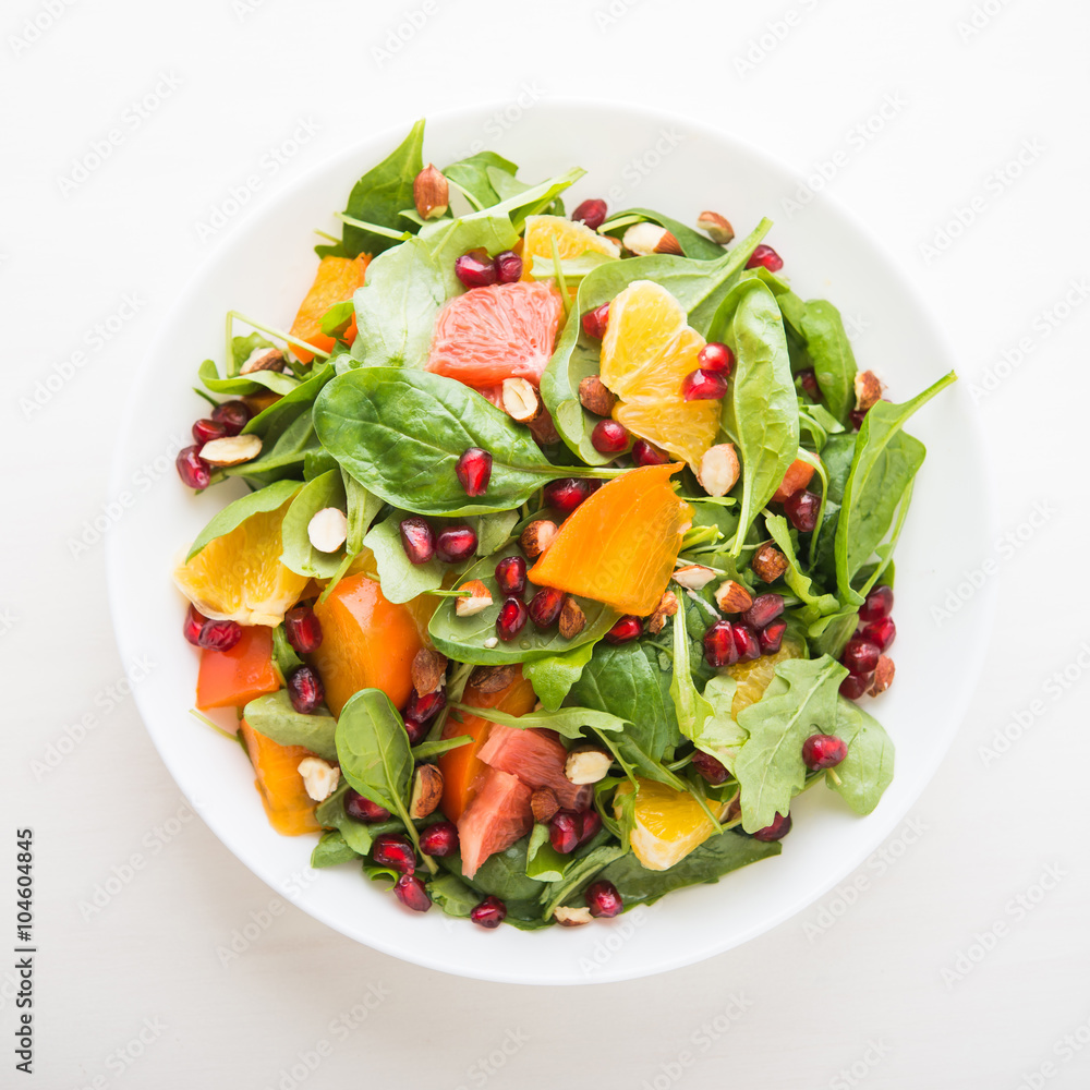 Fresh salad with fruits and greens on white background top view