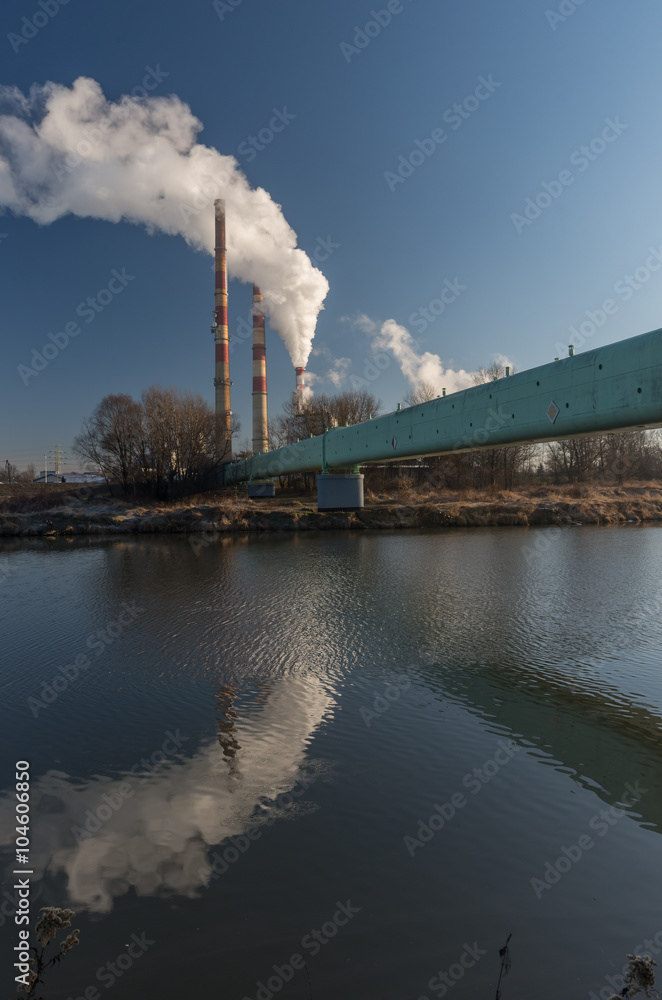 Power plant and overhead pipeline at cold morning over Vistula river, Krakow, Poland