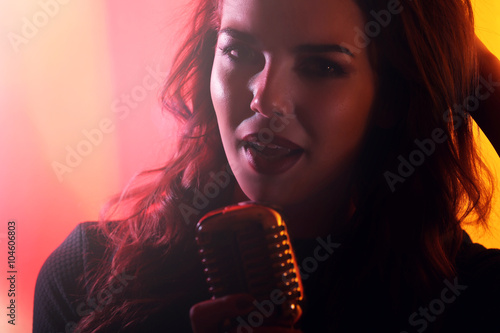 Silhouette of singing woman on colourful background  close up