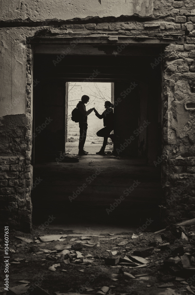 Silhouettes of boy and girl meeting secretly in abandoned space