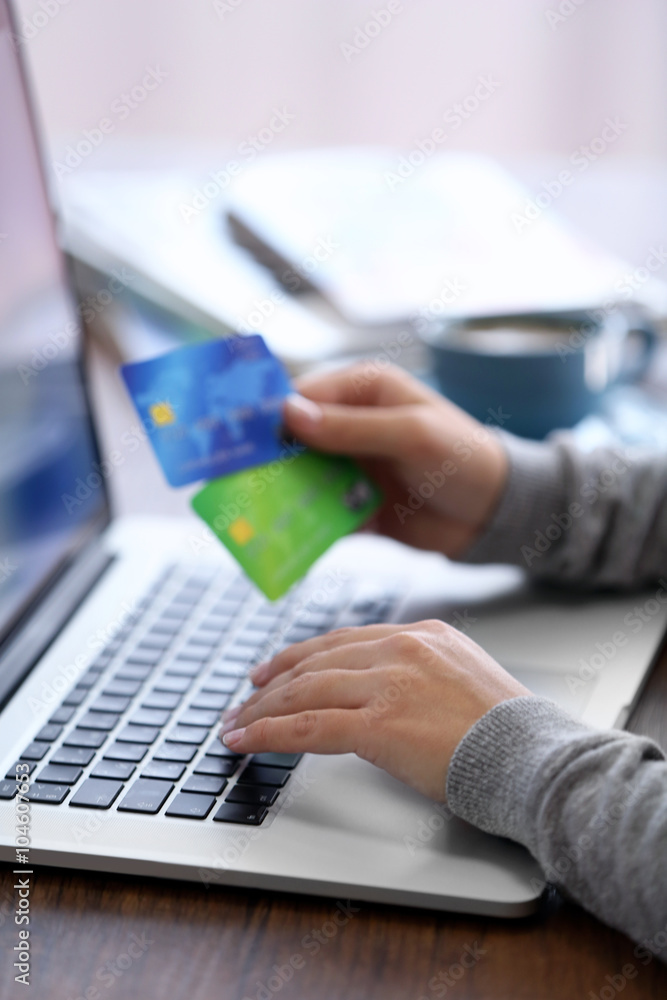 E-commerce concept. Woman with credit card, laptop and cup of coffee, close up E-commerce concept. Woman with credit card, laptop and cup of coffee, close up