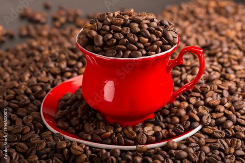 Cup of coffee beans on coffee beans background