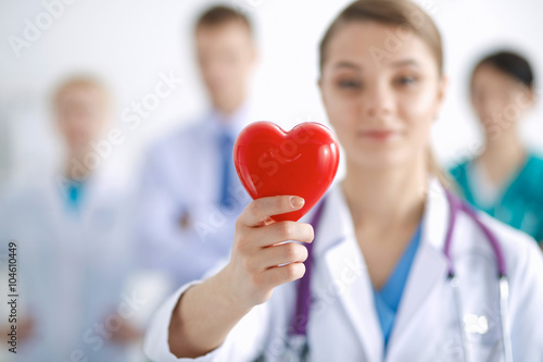 Female doctor with stethoscope holding heart photo