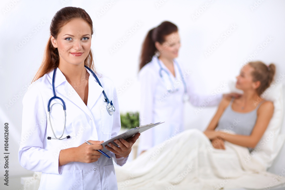 Smiling female doctor with a folder in uniform standing at hospital Smiling female doctor with a folder in uniform standing at hospital