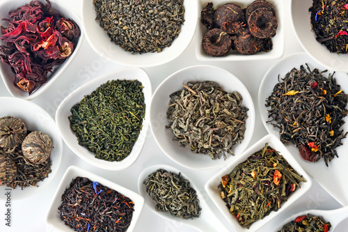 Variety of dry tea in bowls and spoons, closeup photo