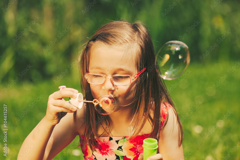 Little girl child blowing bubbles outdoor.