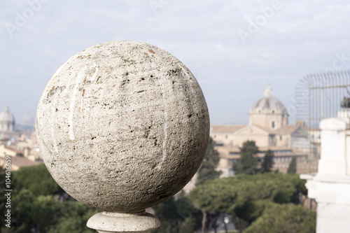 close-up of a ball of travertine marble with the background the view of Rome