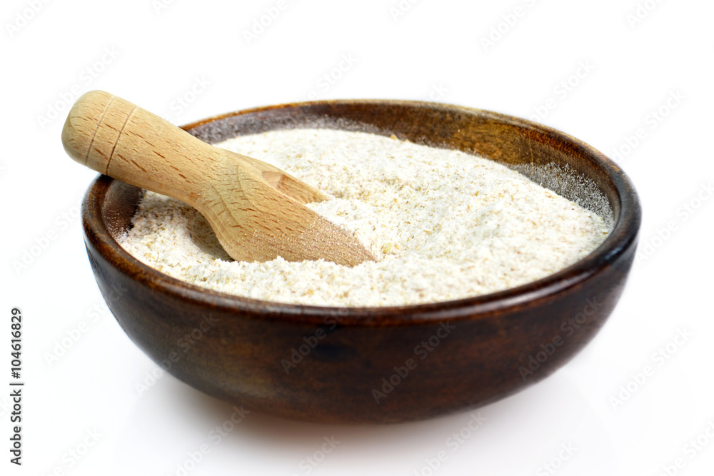 Whole wheat flour in wooden bowl isolated on white background Whole wheat flour in wooden bowl isolated on white background