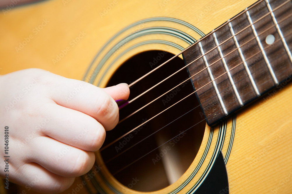Fototapeta premium Little boy is playing the guitar