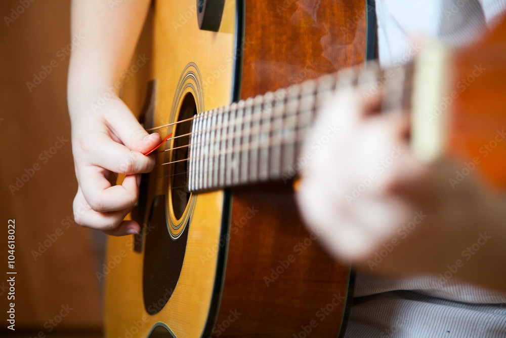 Fototapeta premium Little boy is playing the guitar