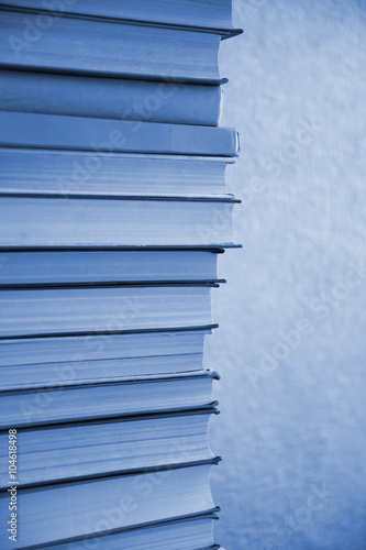 Stack of blue books on light blue background