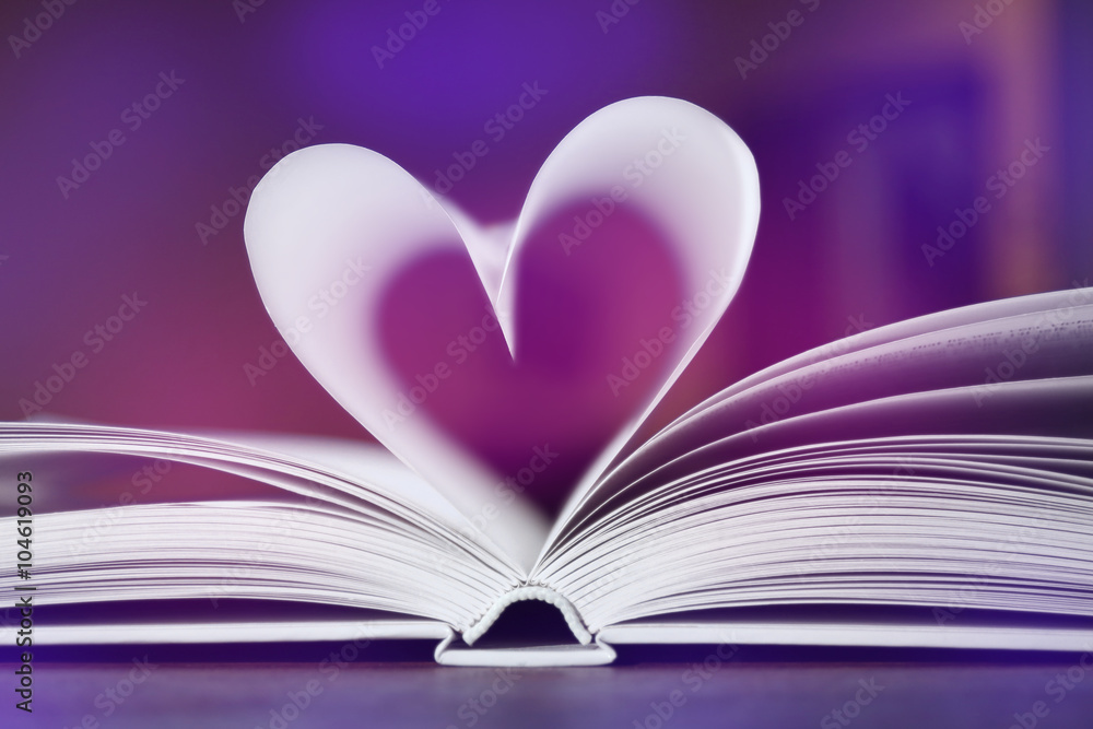 Heart from book pages on dark blurred background Heart from book pages on dark blurred background