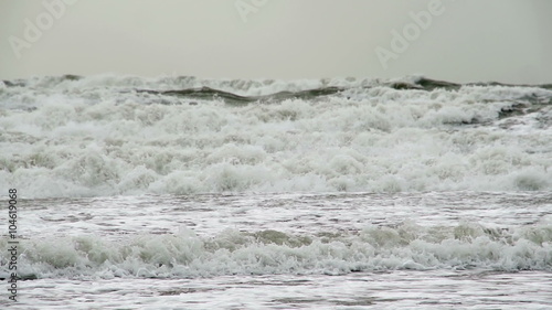 Huge Storm Waves In Super Slow Motion. Winter storms hitting the British coast as large waves crash on a sandy beach photo