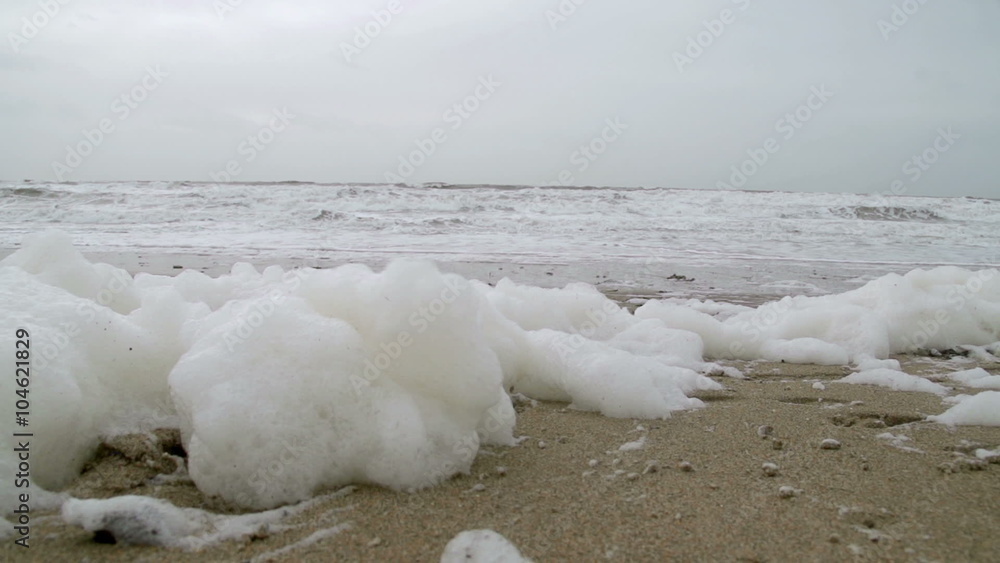 Ocean Surf Foam On A Stormy Winters Day. Winter storms in slow motion seeing the waves crash onto shore with sea spray on sea foam. Ocean Surf Foam On A Stormy Winters Day. Winter storms in slow motion seeing the waves crash onto shore with sea spray on sea foam.