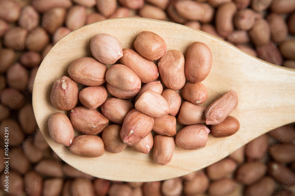 Scoop of peanut on a blurry pile of peanut background.Selective Scoop of peanut on a blurry pile of peanut background.Selective