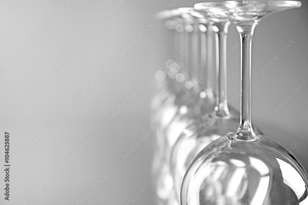 Wine glasses in a row upside down on light grey background Wine glasses in a row upside down on light grey background