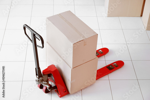 Fork pallet truck with stack of cardboard boxes indoors photo