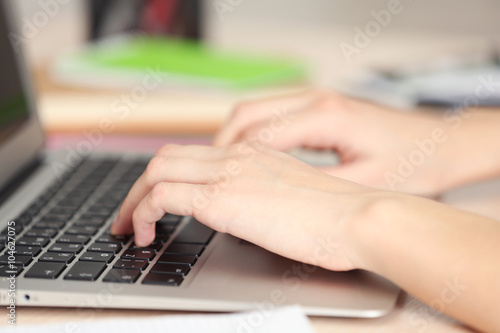 Woman typing on laptop, closeup