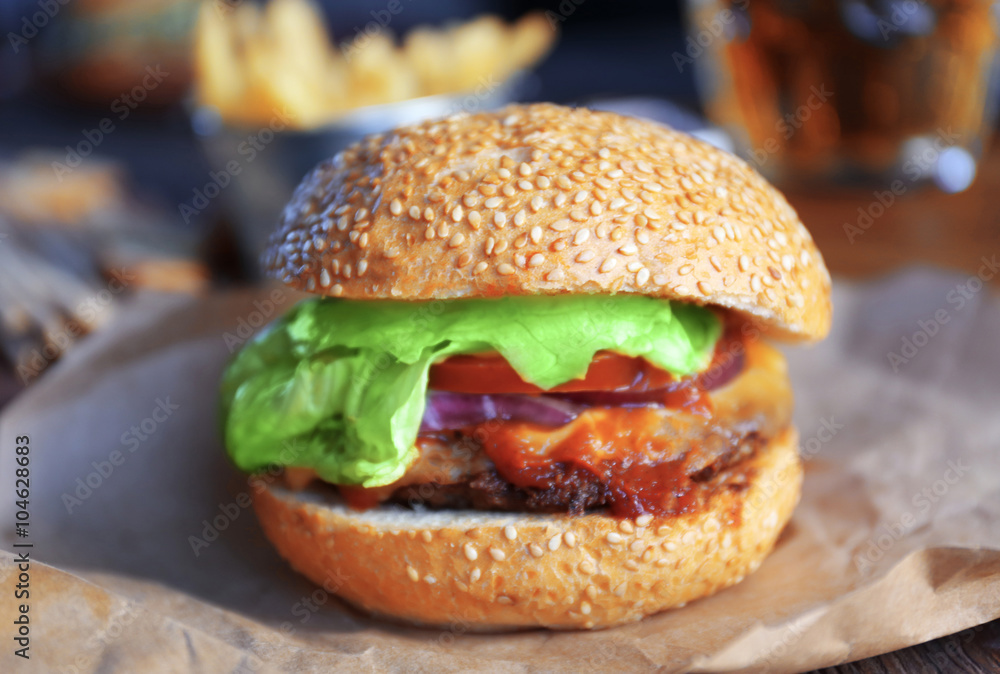 Big tasty hamburger on a paper, close up