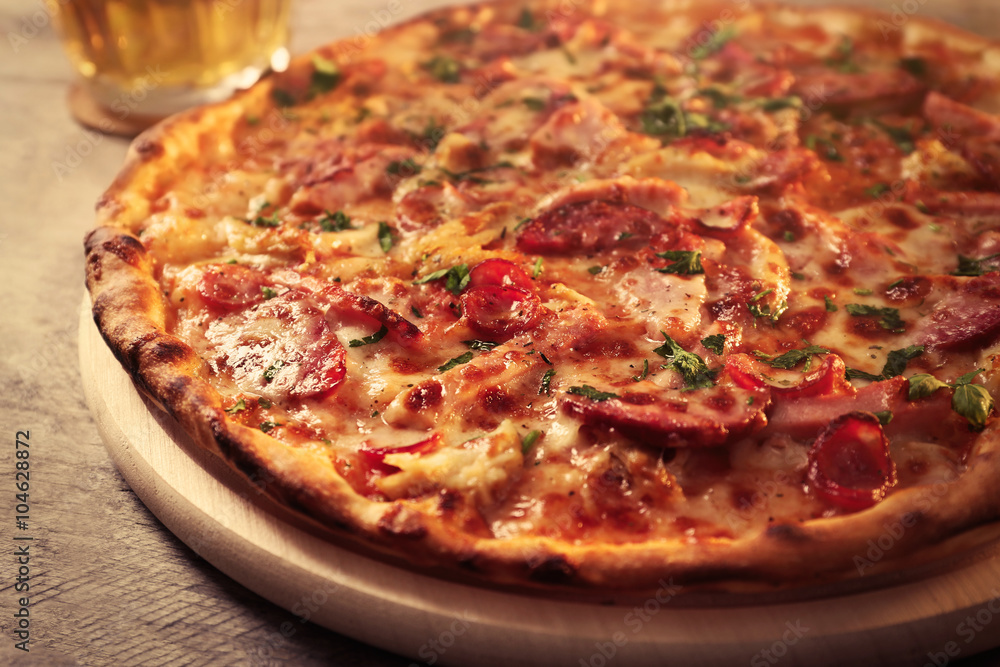 Delicious pizza and glass of beer are on wooden table, close up Delicious pizza and glass of beer are on wooden table, close up