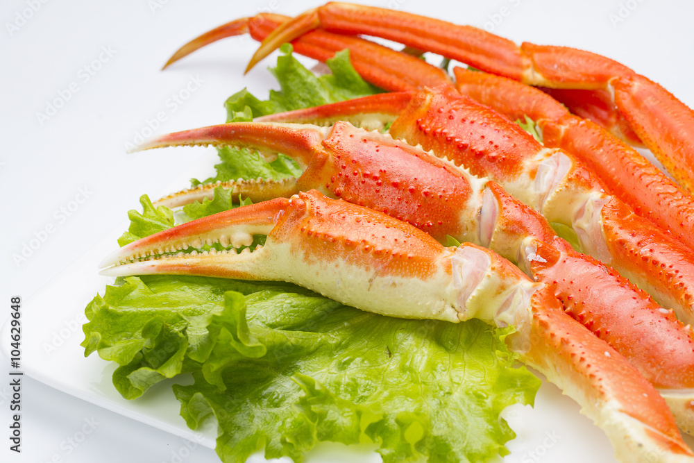 Boiled crab claws with lettuce on a plate ovwe white background
