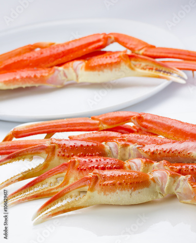 Boiled crab claws on a plate over white background