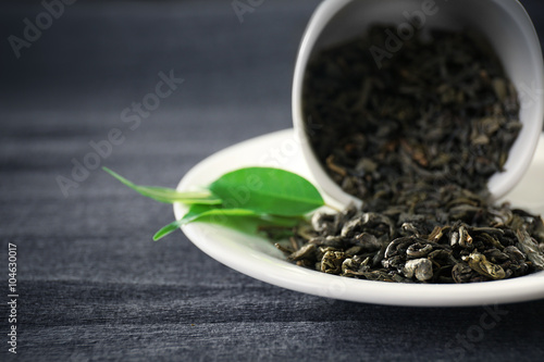 Принти на полотні Granulated tea with green leaves in tea-set on grey background