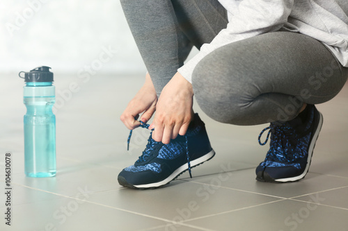 Woman tying up running shoe