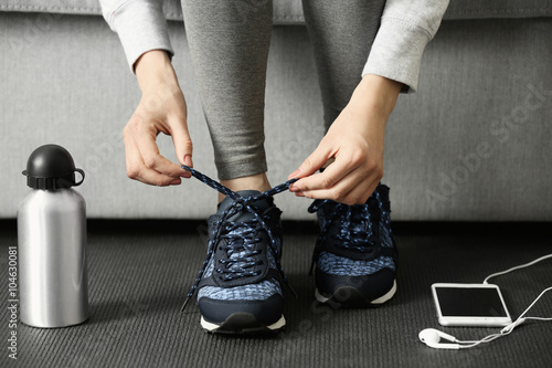 Woman tying up running shoe