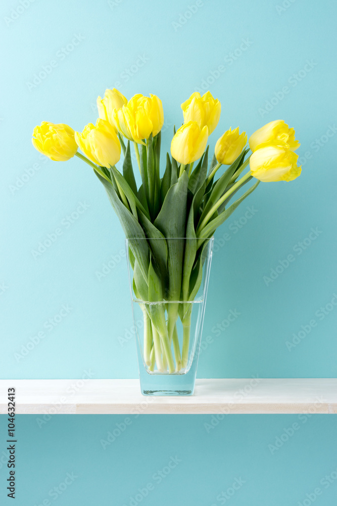青い背景と棚と花瓶と黄色いチューリップ