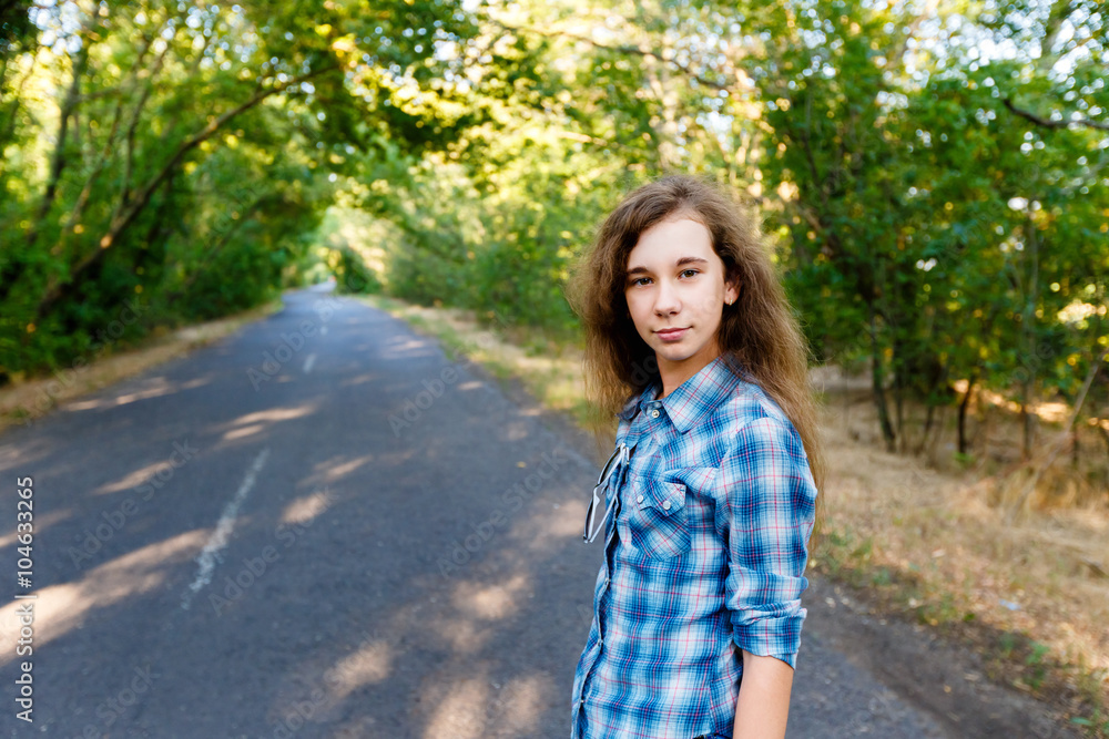 beautiful girl standing on an empty road between green trees beautiful girl standing on an empty road between green trees