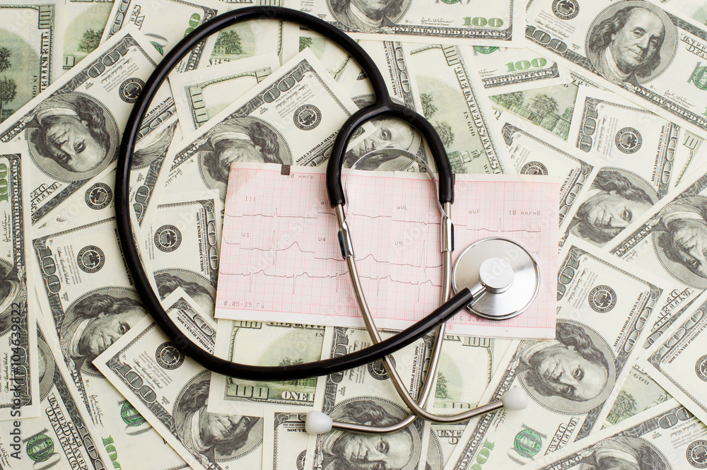 stethoscope over ecg graph and 100 dollar bills stethoscope over ecg graph and 100 dollar bills