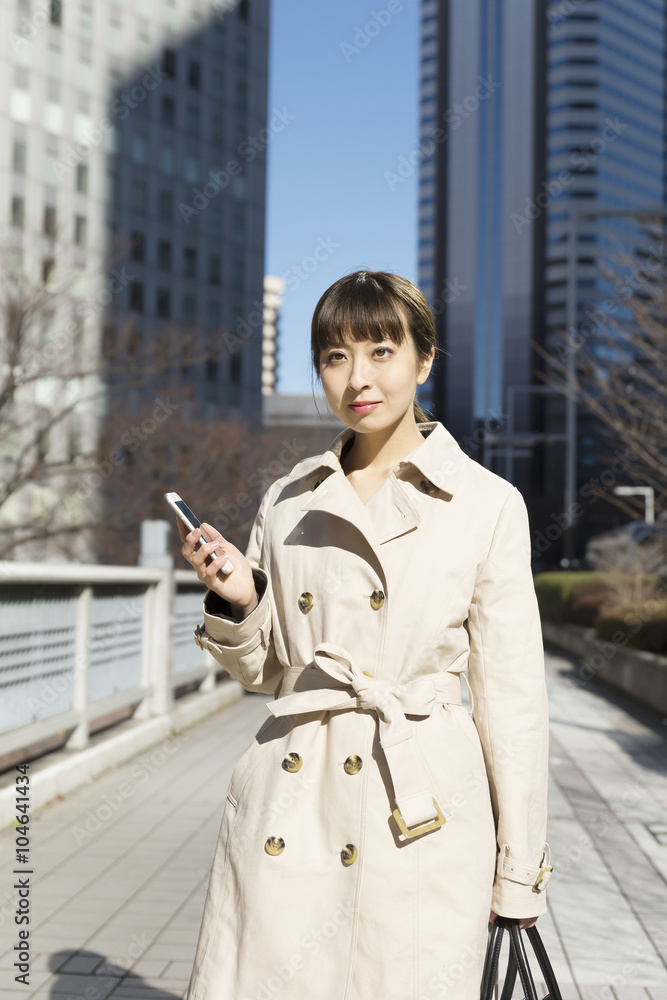 ビジネスウーマン スマホを持つ 屋外 新宿 ビジネス街背景 ビジネスウーマン スマホを持つ 屋外 新宿 ビジネス街背景