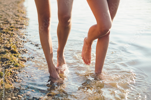 Female legs walking in water