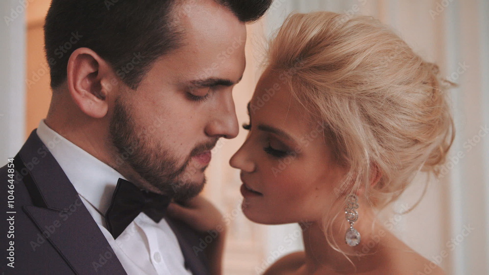 The charming bride and groom look at each other's eyes, hugging each other, close-up face. The charming bride and groom look at each other's eyes, hugging each other, close-up face.