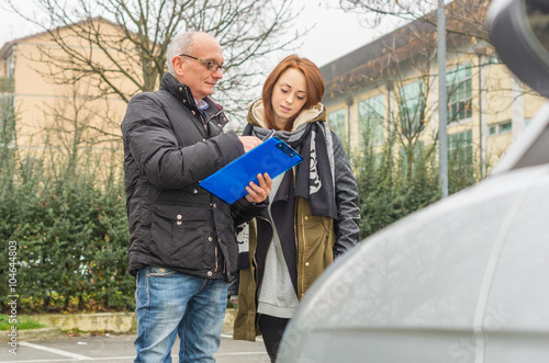 Driving instructor shows results examined to his student - caucasian people - people, lifestyle and driving school concept photo