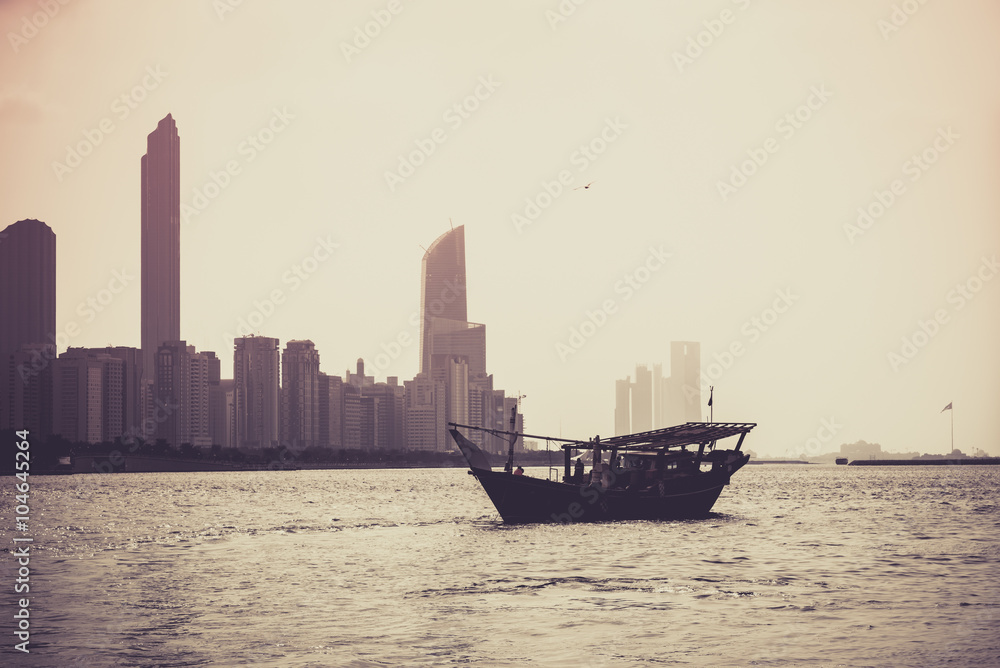 Fototapeta premium Abu Dhabi buildings skyline with old fishing boat