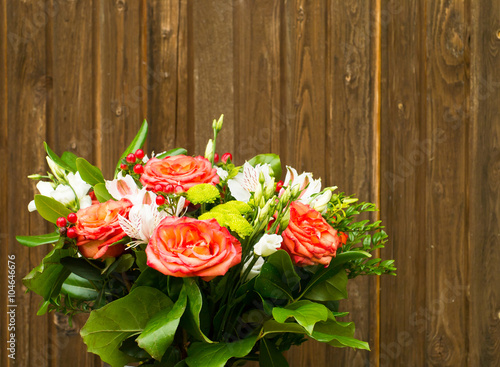 bouquet of beautiful flowers with roses on a old wooden background with copy space