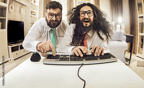 Two nerdy guys working with a computer photo