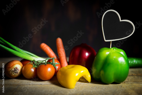 Auswahl verschiedener Gemüse auf altem Holztisch, Herz mit Text