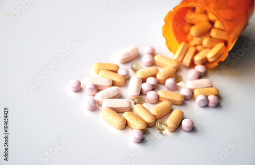 Foto different drugs and health supplement pills poured from a medicine bottle