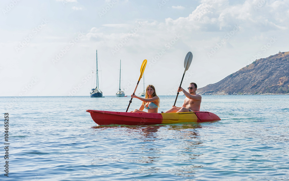 Couple exploring calm tropical bay by kayak.